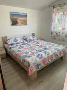 sypialnia z łóżkiem z kołdrą kwiatową w obiekcie Apartment Sandra - 40m from the sea & parking w Nin