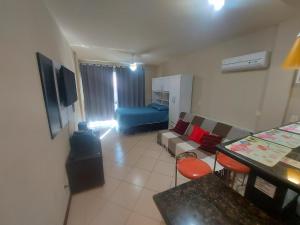 a living room with a couch and a blue bed at loft Prainha in Arraial do Cabo