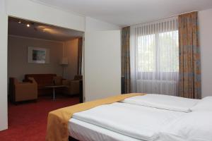 um quarto de hotel com uma cama e uma sala de estar em Hotel Gästehaus Forum am Westkreuz em Munique