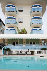 un hotel con piscina frente a un edificio en Hotel Canarie, en Lido di Jesolo