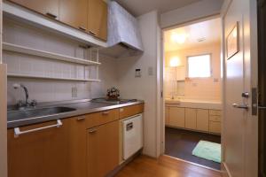 a kitchen with wooden cabinets and a sink and a window at Shinnishiki Hotel in Shirahama