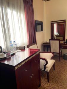 a hotel room with a desk and chairs at Boulevard Palace Hotel in Monrovia