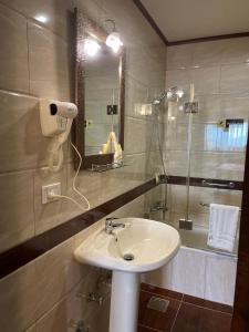 a bathroom with a sink, toilet and bathtub at Boulevard Palace Hotel in Monrovia