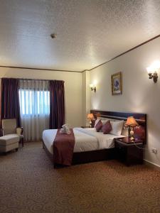 a hotel room with a large bed and a chair at Boulevard Palace Hotel in Monrovia