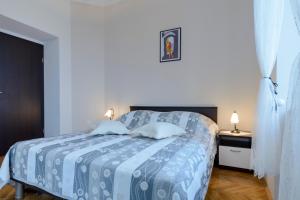 a bedroom with a blue and white bed with two lamps at Apartments Pully in Dubrovnik