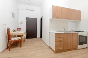 a kitchen with a table and a sink and a stove at Apartments Pully in Dubrovnik