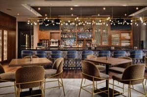 a restaurant with tables and chairs and a bar at The Forester Hotel, part of Unscripted by Hyatt in Lake Forest
