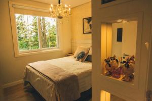 a bedroom with a bed and a window at Apto Fofo in Gramado