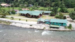 an aerial view of a house next to a river at Tambatuon Homestead in Kota Belud