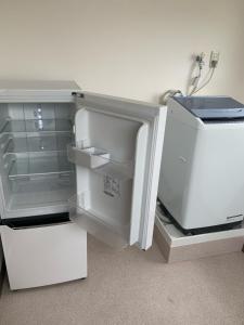 an empty refrigerator with its door open in a room at Business Hotel TenTen in Okayama