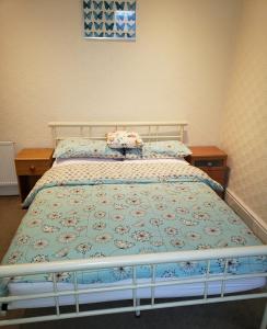 a bedroom with a bed with a blue and white bedspread at Fernlea Hotel in Blackpool