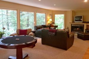 ein Wohnzimmer mit Sofas, einem Tisch und einem Kamin in der Unterkunft Snowline Cabin #29 - An Ultra Custom Family Vacation Home! in Glacier