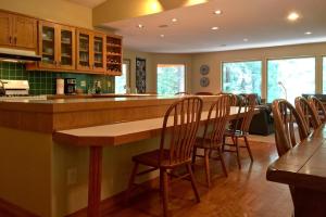 eine Küche mit einer Bar mit Stühlen drum herum in der Unterkunft Snowline Cabin #29 - An Ultra Custom Family Vacation Home! in Glacier