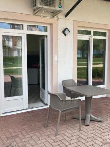 a patio with a table and chairs and sliding glass doors at Zamárdi Parti Apartman 1 in Zamárdi