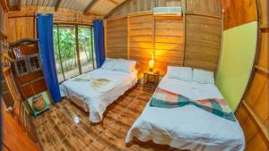 a small room with two beds and a window at Cabañas del Lago in Fortuna