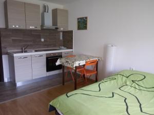 a kitchen with a table and a bed in a room at Monolocale Belvedere in Bovec