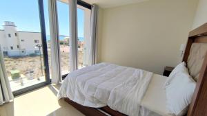 a bedroom with a bed and a large window at Condominios Costa Diamante in San Carlos +23 photos