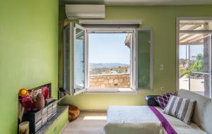 a bedroom with a bed and a large window at Stone House Yiota in Plaka Milou