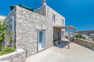 a stone villa with a patio and an awning at Stone House Yiota in Plaka Milou