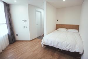 En eller flere senge i et værelse på Kenny Stay Jeju Mosulpo