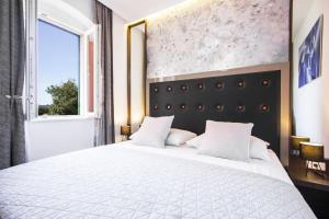ein Schlafzimmer mit einem großen weißen Bett und einem Fenster in der Unterkunft Argentum Luxury Apartment in Split