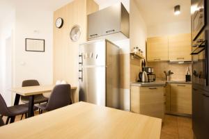 eine Küche mit einem Kühlschrank aus Edelstahl und einem Tisch in der Unterkunft Argentum Luxury Apartment in Split