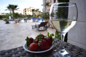 a plate of strawberries and a glass of wine on a table at Cascadas Ravda - Gorgeous 2 bedrooms family apartment in Ravda