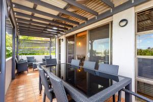 een patio met een tafel en stoelen op een balkon bij Como Mezzanine Retreat in Perth