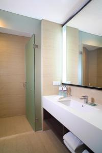 een badkamer met een wastafel en een grote spiegel bij Hotel Santika Premiere ICE - BSD City in Serpong