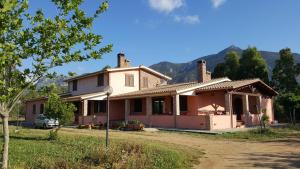 una vecchia casa con montagne sullo sfondo di Villa nel verde a Iglesias