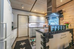 列維的住宿－Arctic Star Levi - Riekon Lumo，厨房配有白色橱柜和黑色台面