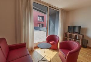 a living room with two chairs and a table and a window at Piazza Lira Schio Residence in Schio