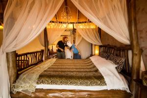un hombre y una mujer de pie junto a una cama grande en The Dew B&B 晨露庄 民宿, en Dongshan