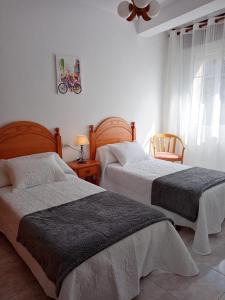 - une chambre avec 2 lits et un ventilateur de plafond dans l'établissement Apartamento A Canteira, à O Grove