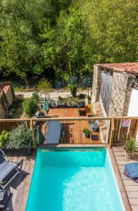 una terrazza in legno con vista sulla piscina. di Villa Mélusine ad Arçais