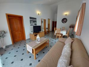 - un salon avec un canapé et une table dans l'établissement Apartments Palić, à Baška