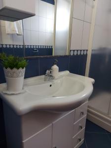 a bathroom with a white sink and a mirror at Apartments Palić in Baška +41 photos