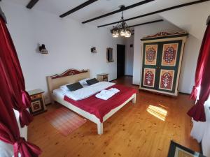 a bedroom with a bed with a red blanket at Pensiunea Casa Moga in Bucium