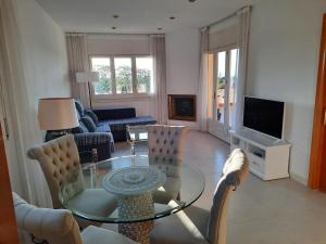 salon ze szklanym stołem i krzesłami w obiekcie Apartamento Vistas golf Bonmont w mieście Bonmont Terres Noves