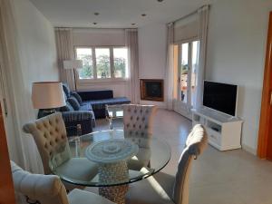 uma sala de estar com uma mesa de vidro e cadeiras em Apartamento Vistas golf Bonmont em Bonmont Terres Noves