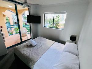 a bedroom with a white bed and a window at Aruba Surf Resort in Gold Coast +68 photos