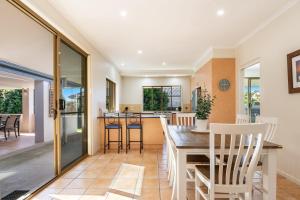 a kitchen and dining room with a table and chairs at A Wave From It All - Lennox Head in Lennox Head