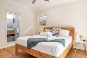 a bedroom with a large bed and a bathroom at A Wave From It All - Lennox Head in Lennox Head