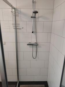 een badkamer met een douche met witte tegels bij Het Duintje in Scharendijke