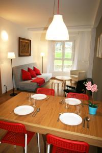 sala de estar con mesa de madera y sillas rojas en Apartamento Labegain 1, en Sestao