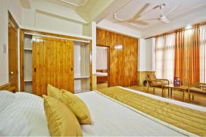 una camera da letto con un letto grande e una scrivania di Hotel Snow View Manali a Manāli