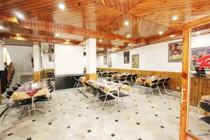un ristorante con tavoli e sedie in una stanza di Hotel Snow View Manali a Manāli