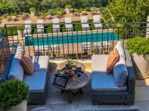 Mougins Luxury Retreats في موجان: كرسيين وطاولة على شرفة مع مسبح