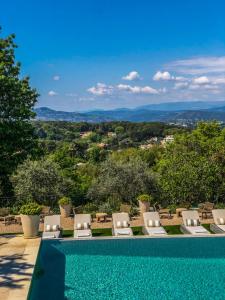 - une piscine avec des chaises longues et une vue dans l'établissement Mougins Luxury Retreats, à Mougins