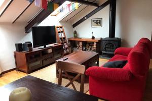 - un salon avec deux chaises rouges et une télévision dans l'établissement Apartamento en pleno Centro CATEDRAL, à Oviedo